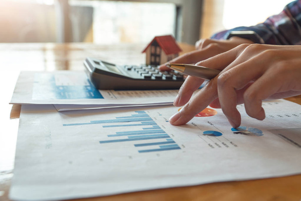 Kobieta naciśnij Kalkulator do obliczenia finansowe wykresu dla inwestycji na zakup nieruchomości - Zdjęcie, obraz
