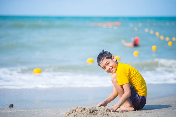 Garçon jouant vague et sable sur la plage
 - Photo, image