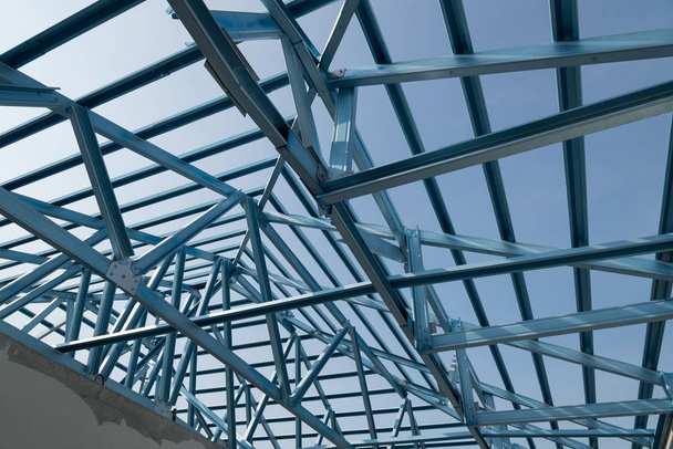 Estructura del marco de techo de acero para la construcción de edificios aislados sobre fondo azul del cielo
. - Foto, Imagen