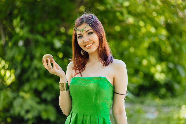 Portrait of a beautiful young asian woman dressed like a princess with fresh kiwi - Foto, afbeelding