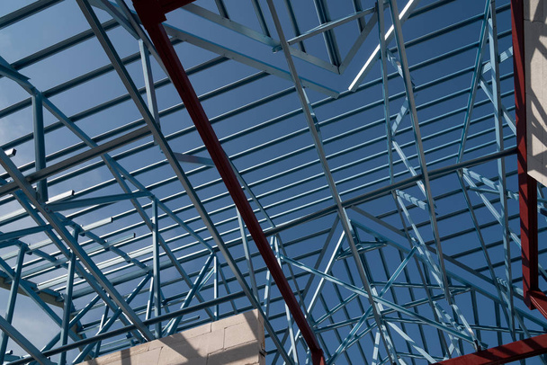 Struktur aus Stahl Dachstuhl für Hochbau isoliert auf blauem Himmel Hintergrund. - Foto, Bild