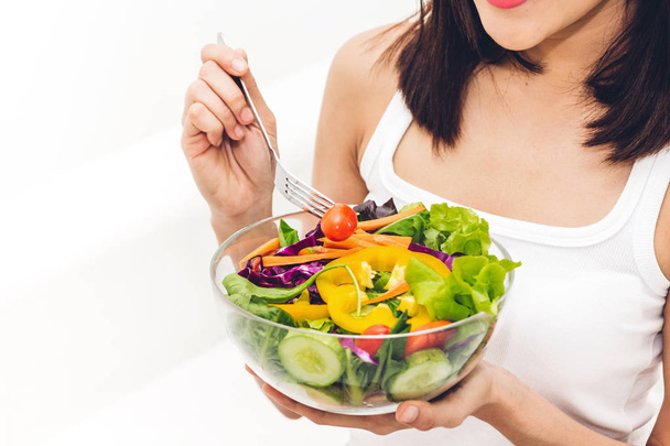 Onnellinen nainen syö ja näyttää terveellistä tuoretta salaattia bowl.dieting käsite.
 - Valokuva, kuva