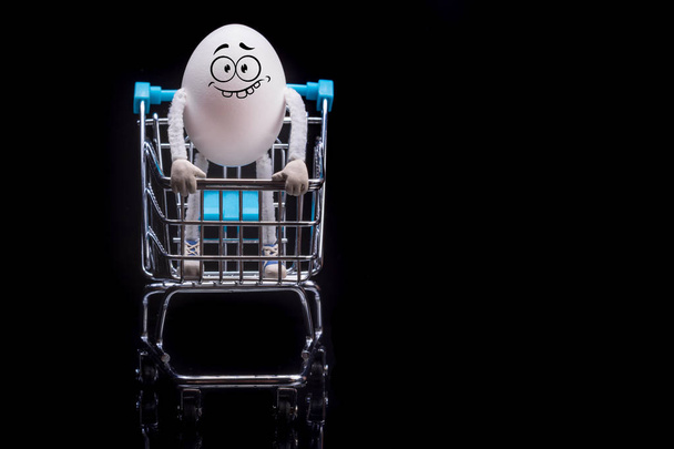 Счастливое яйцо, стоящее на тележке из супермаркета. Пространство для текста
. - Фото, изображение