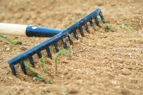 Working In Garden With Rake Leveling Ground. Work In Garden With Rake. Preparation Of Ground For Seeding and Planting. - Foto, Imagen