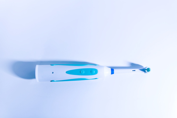 Современная электрическая зубная щетка для здоровых зубов на светлом мягком фоне
. - Фото, изображение