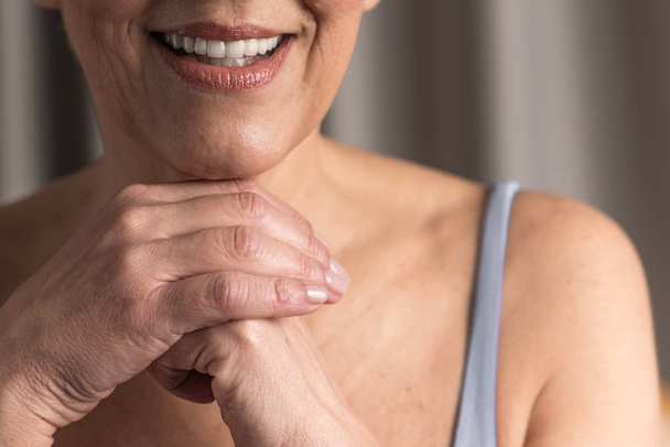 cropped photo of senior female hands and lips with beautiful smile - Fotoğraf, Görsel