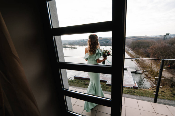 bride holding bouquet of wedding flowers on balcony  - Fotó, kép