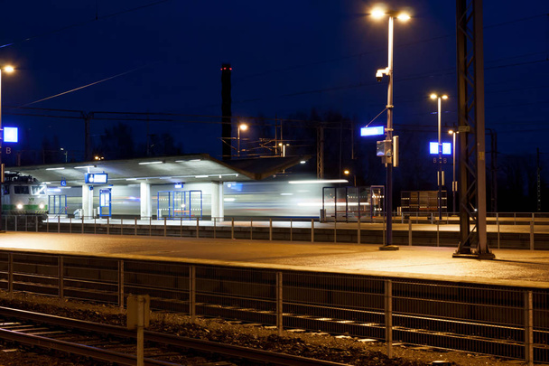 Comboio em movimento na estação à noite, foto de longa exposição
 - Foto, Imagem