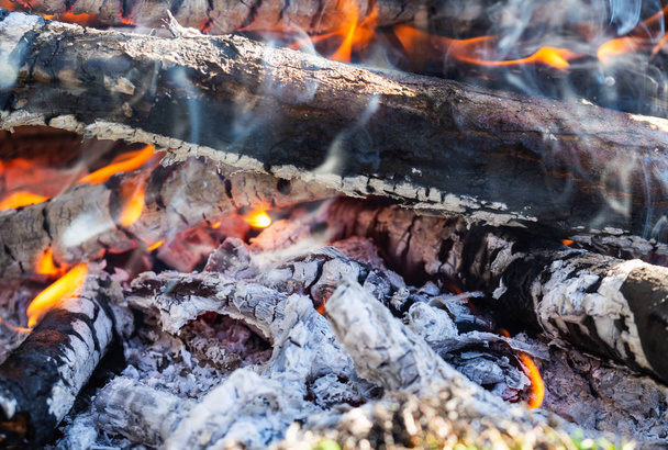 Lagerfeuer mit brennendem Brennholz, Makro. Glut glüht im Kamin - Foto, Bild