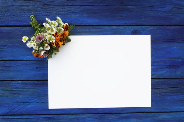 Mavi eski püskü ahşap arka planda mesajlaşmak için boş kağıtlı yaz çiçekleri.. - Fotoğraf, Görsel