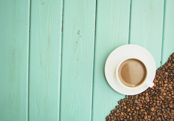 Granos de café negro sobre fondo turquesa
 - Foto, Imagen