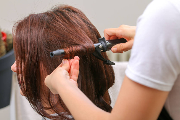 Girl in beauty salon while an hair stylist dry her hair - Φωτογραφία, εικόνα