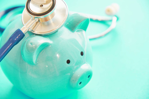 скарбничка і стетоскоп на синьому фоні, концепція медичних витрат. банкрутська реанімація
 - Фото, зображення