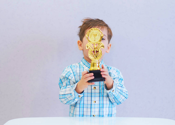 divertido chico edad tres años de edad, celebración en la celebración de un trofeo
 - Foto, Imagen