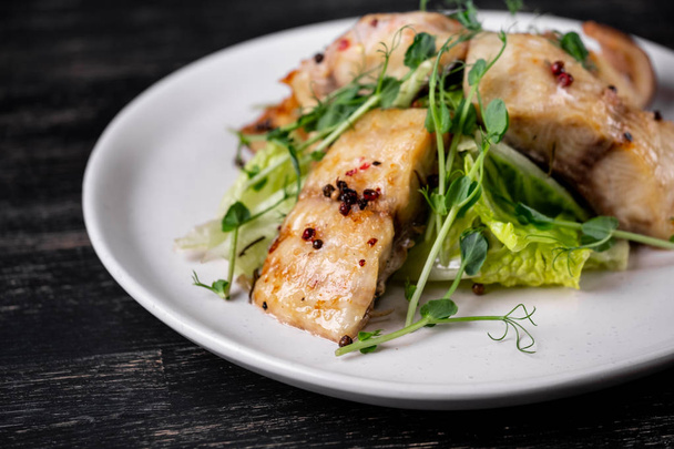 白皿の上緑エンドウ豆もやしとスパイス焼きの白い魚のスライス - 写真・画像