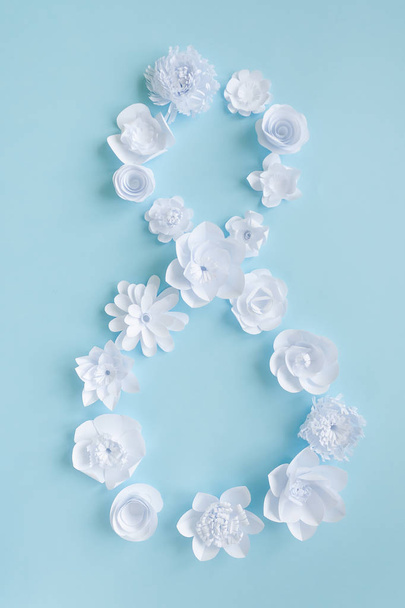 Figure 8 from white paper flowers on blue background. Women day - Foto, immagini
