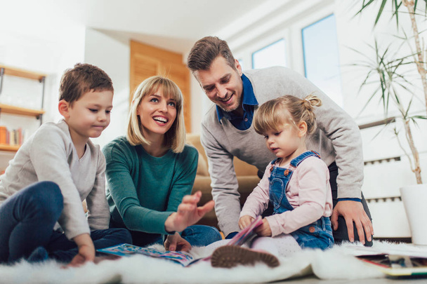 glückliche Familie, die Spaß auf dem Fußboden oder im Wohnzimmer zu Hause hat, lacht, selektiver Fokus. - Foto, Bild