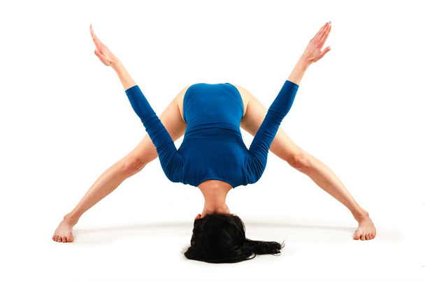 Beautiful healthy woman practices yoga in turquoise body isolated on white background. Yoga asanas. Hatha yoga - Photo, Image
