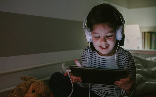 Girl with headphones looking at the tablet - Photo, Image