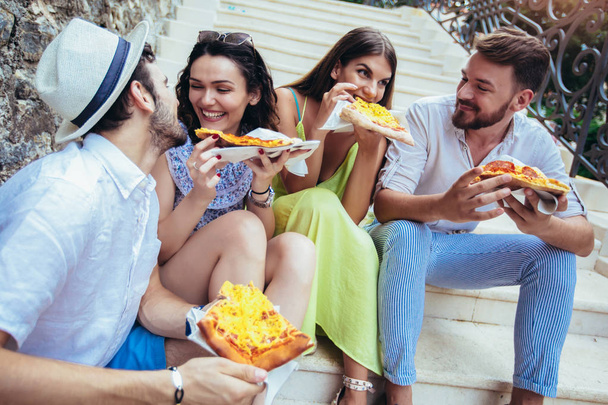 Gente feliz comiendo comida rápida en la ciudad mientras viaja
 - Foto, imagen