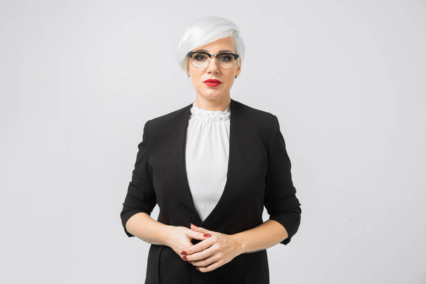 Retrato de uma senhora de negócios confiante em um terno rigoroso isolado em um fundo leve
 - Foto, Imagem