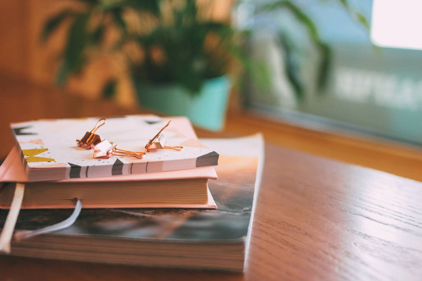Περιοδικό, ημερολόγιο, αυτοκόλλητα, συνδετήρες χαρτικά στο τραπέζι στην καφετέρια - Φωτογραφία, εικόνα