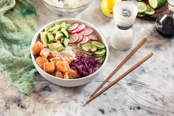 Poke bowl, traditional Hawaiian raw fish salad with rice, avocado, cucumber and radish on bright background - Fotoğraf, Görsel