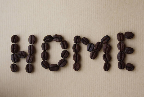 茶色い紙の質感にコーヒー豆の家の言葉 - 写真・画像