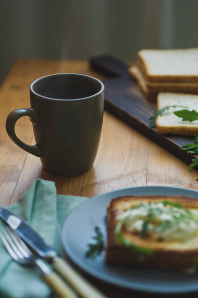 sandwich with egg and arugula on a plate is on the table - Photo, Image