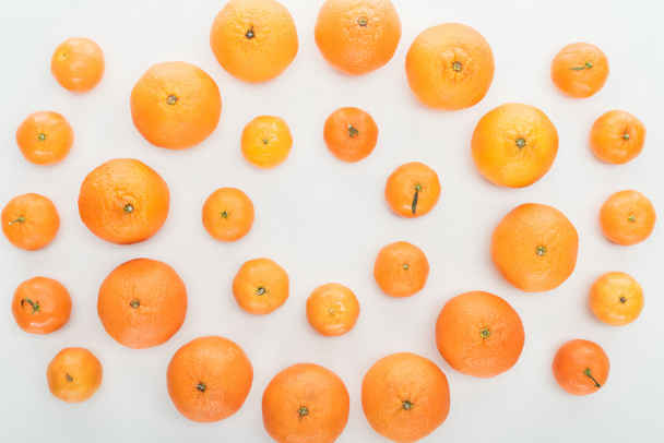 tendido plano con mandarinas anaranjadas brillantes maduras sobre fondo blanco
 - Foto, Imagen