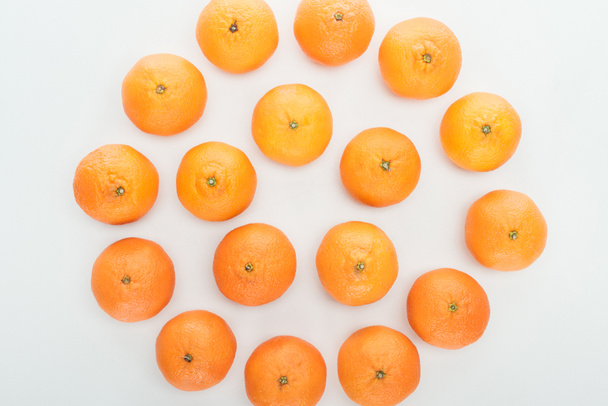 top view of ripe orange tangerines arranged in circle on white background - Foto, afbeelding