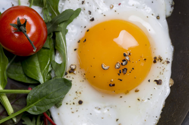 Close up yolk of egg with salad and tomatoes. View from above, horizontal - Fotoğraf, Görsel