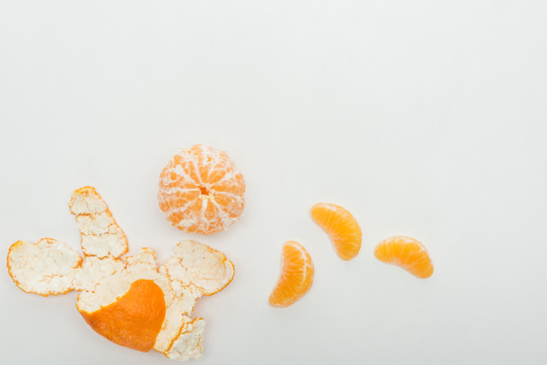 top view of whole tangerine, slices and peel on white background  - Foto, Imagen