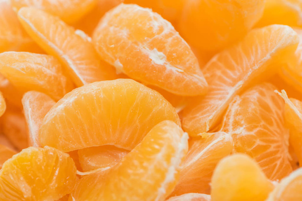 крупным планом из ярко-оранжевого мандарина очищенных ломтиков
  - Фото, изображение