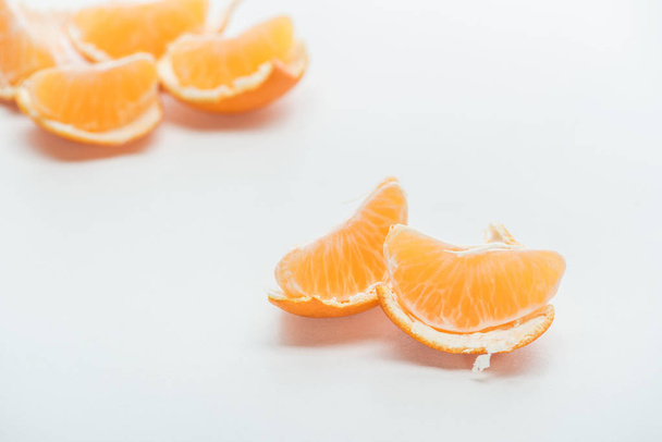 selective focus of tangerine slices with peel on white background - Foto, Imagem
