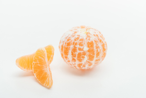 tangerine slices and ripe orange whole fruit on white background - Foto, Imagen