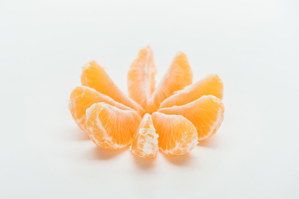 白い背景の上の円で整理される熟したオレンジ タンジェリン スライス - 写真・画像