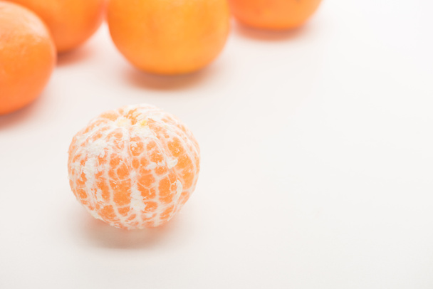 selective focus of ripe peeled whole tangerine on white background - Photo, Image