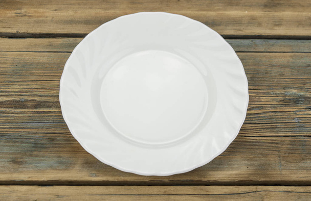 plato blanco vacío sobre fondo de madera - Foto, Imagen
