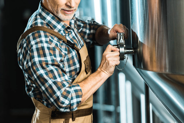 シニア男性ビール醸造所装置の操作のビューをトリミング - 写真・画像