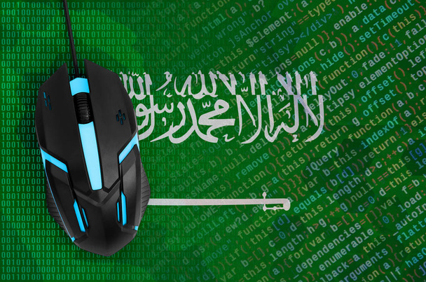 Vlag van Saoedi-Arabië en moderne backlit computermuis. Het concept van digitale dreiging, illegale acties op Internet - Foto, afbeelding