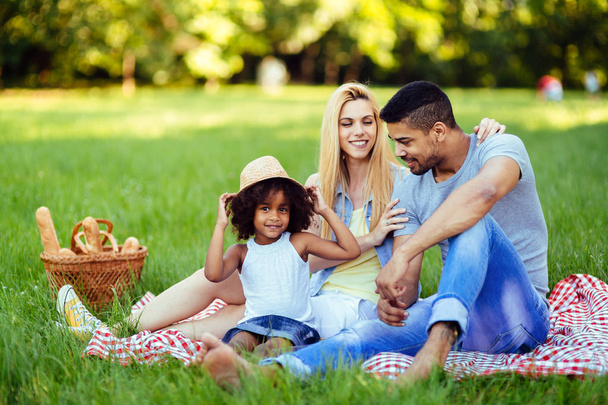 Picture of lovely couple with their daughter having picnic in nature - Photo, image