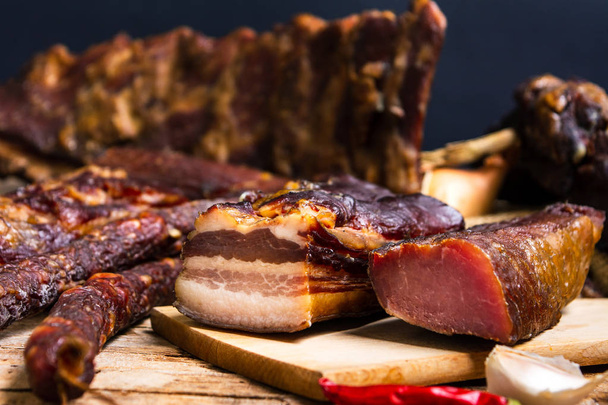 Homemade bacon and smoked pork meat on a cutting board - Photo, Image