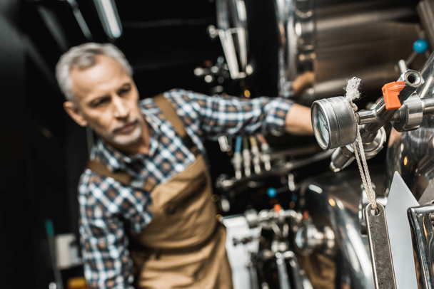プロの男性ビール醸造所装置の操作の選択と集中 - 写真・画像