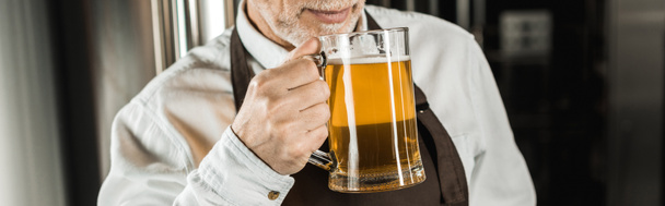 cropped view of senior brewer testing beer in brewery - Фото, изображение