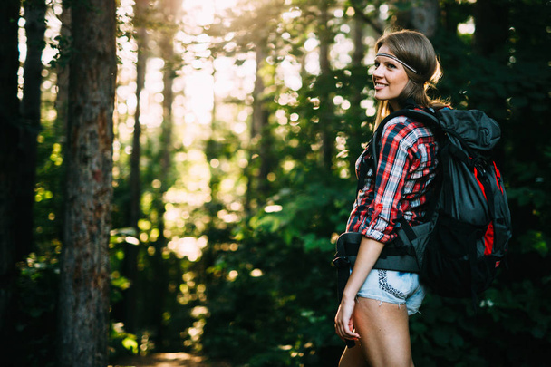 Portrait of pretty backpacker woman hiking in forest - Foto, Imagem