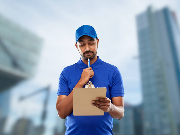indian delivery man with clipboard in blue - Foto, Imagen