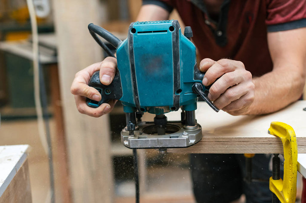 Design-Holzkonzept. zugeschnittenes Foto von Tischler Handwerker Mann Tauchwerkzeug in Holz halten Holzwerkzeug in den Händen - Foto, Bild