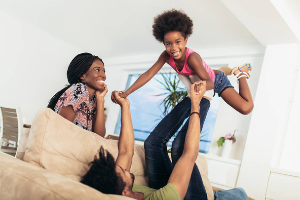 Afro-Amerikaanse familie brengt tijd samen door thuis. Ze hebben plezier. - Foto, afbeelding