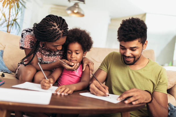 Mom and dad drawing with their daughter. African american family spending time together at home. - Fotoğraf, Görsel